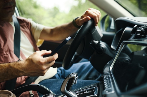 Man Looking At Phone While Driving - Distracted Driving
