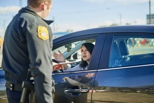 Police officer pulling over a woman suspected of driving under the influence illustrating the legal consequences of Drunk Driving Accidents.