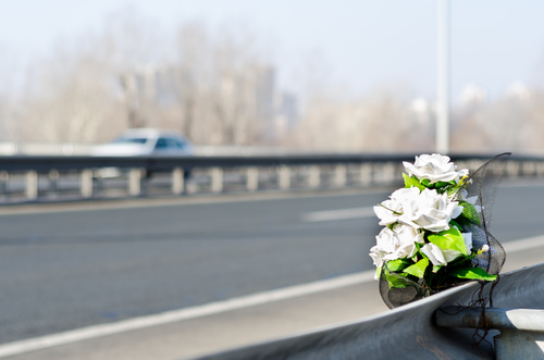 Artificial white roses mark the site of a fatal car accident.