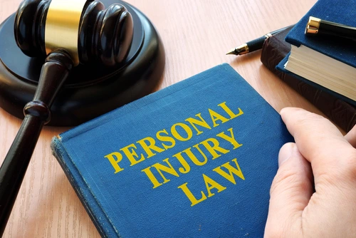 A Lenoir City personal injury lawyer holds a personal injury law book.