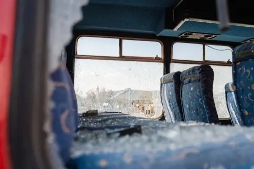 Lenoir City bus accident lawyer investigating bus with smashed window after serious crash.