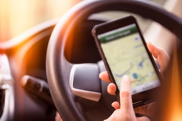 The rideshare app displayed on a woman's phone represents an Uber accident lawyer.