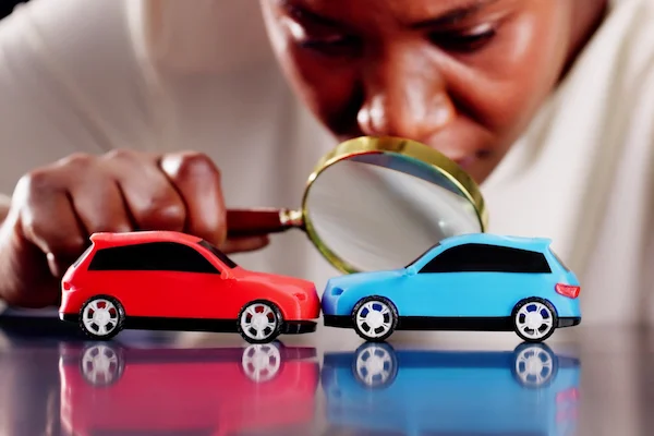 A car accident reconstruction expert with a magnifying glass represents expert witnesses.