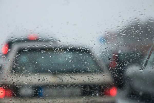 Cars driving in rain represent how weather conditions influence car accident claims